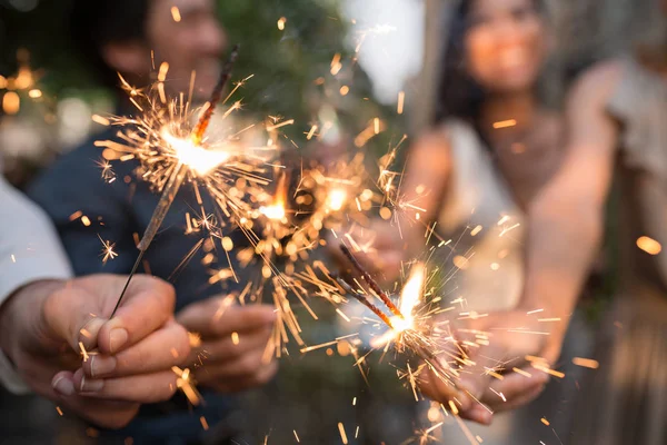 Pessoas segurando luzes brilhantes de bengala — Fotografia de Stock