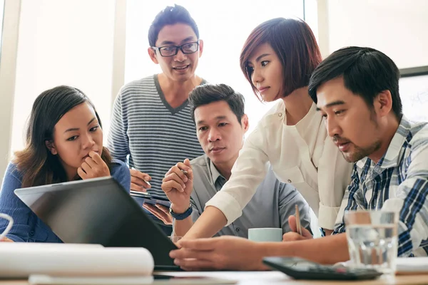 Equipo de negocios se reunió frente a la computadora portátil — Foto de Stock