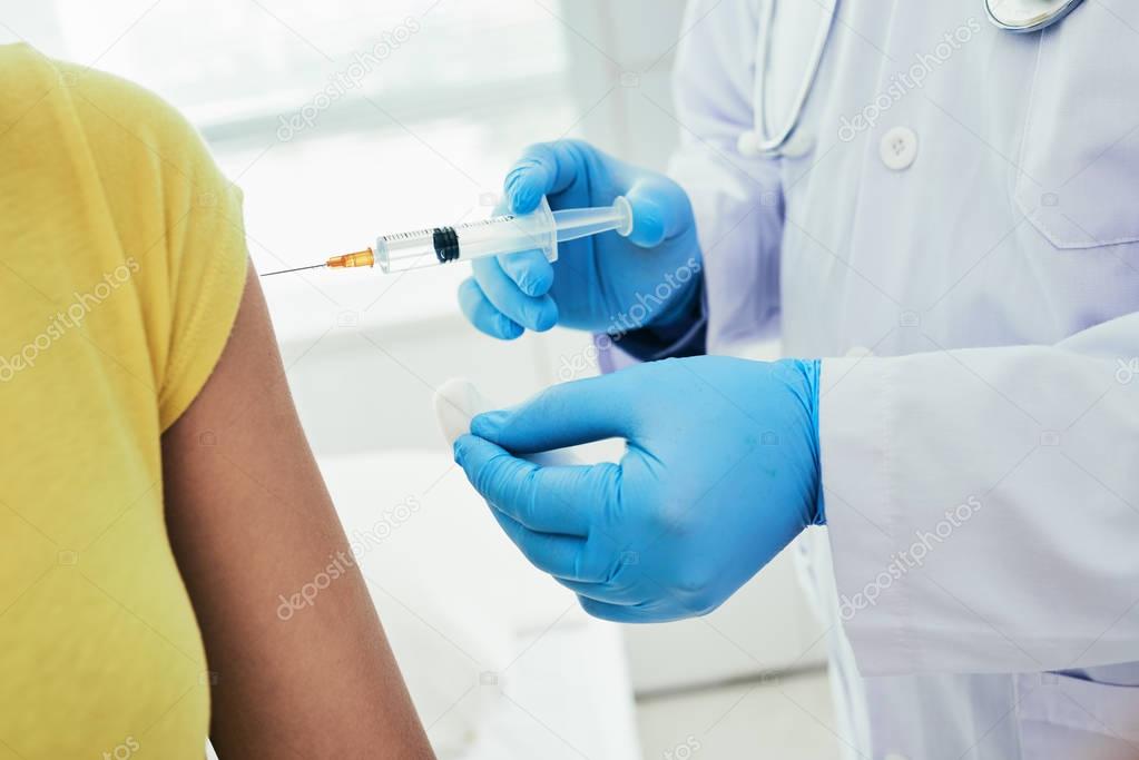 Doctor making vaccine to patient