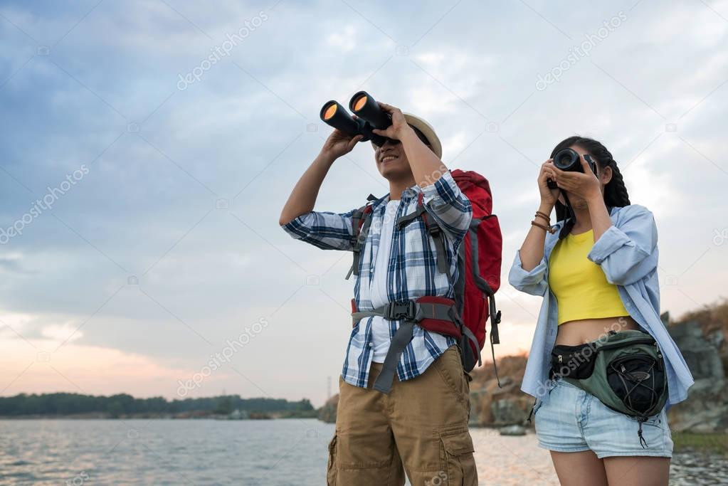 tourists looking at binoculars and tking photos