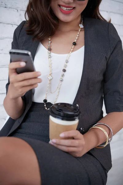 Femme d'affaires appréciant le café lors de la vérification smartphone — Photo