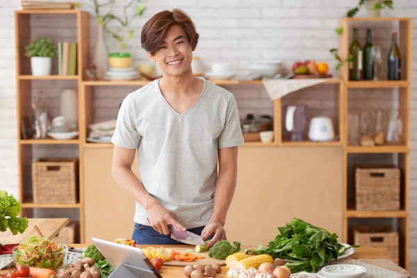 Hombre cocina ensalada en la cocina —  Fotos de Stock