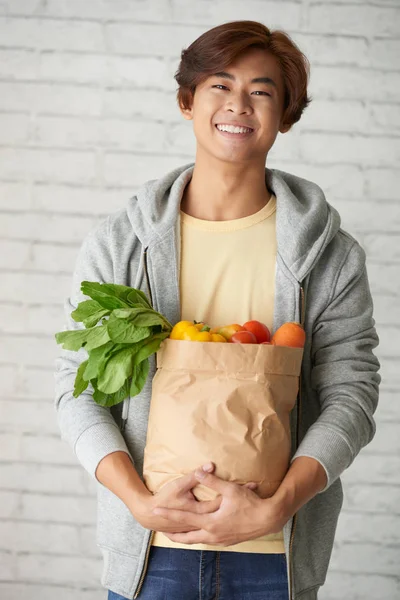 Hombre llevando un paquete grande con comestibles —  Fotos de Stock