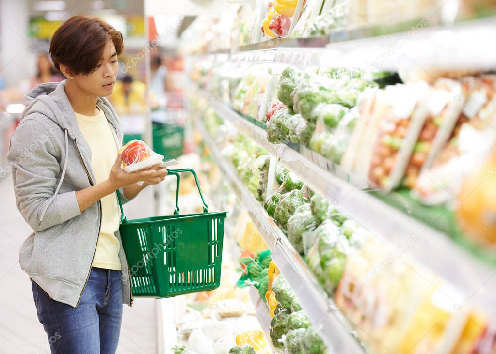 man choosing vegetables in supermarket
