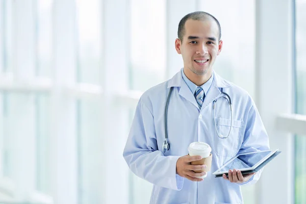 Läkare med tablett och kaffe — Stockfoto