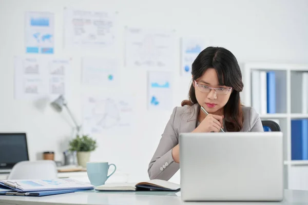 Geschäftsfrau liest Informationen auf Laptop-Bildschirm — Stockfoto