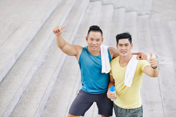 Mannen knuffelen en tonen thumbs-up — Stockfoto