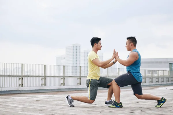 Desportistas fazendo lunges ao ar livre — Fotografia de Stock