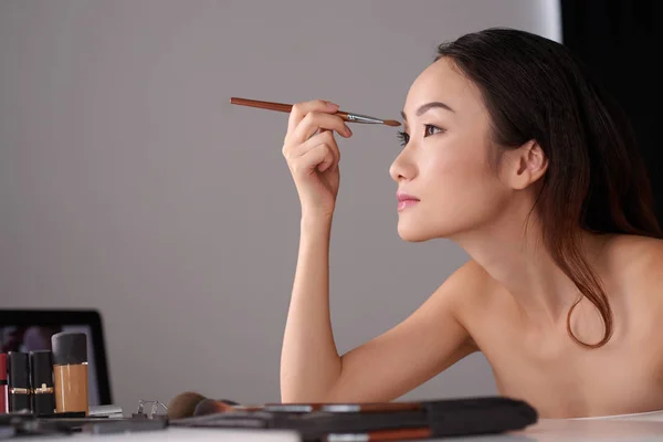 Chica haciendo maquillaje de ojos —  Fotos de Stock