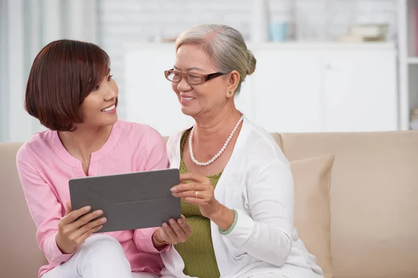 Tablet bilgisayar ile kadın ve yetişkin kızı — Stok fotoğraf