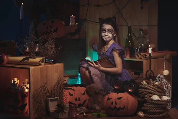 Meisje met boek bij Halloweenfeest — Stockfoto