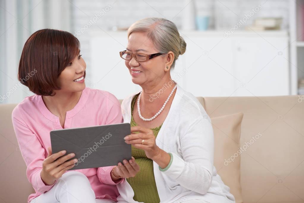 woman and adult daughter with tablet computer