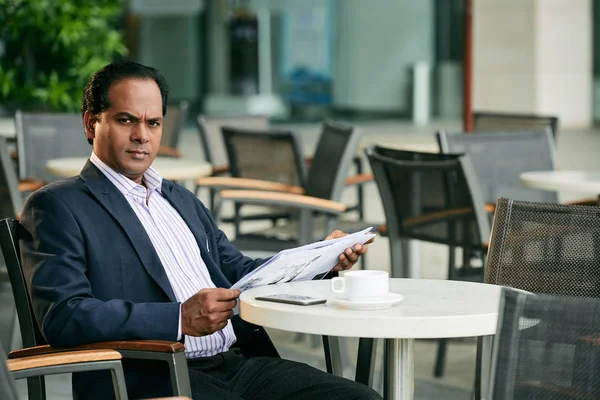 Empresário com jornal sentado no café — Fotografia de Stock