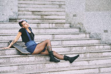 kaykay sonra basamaklarında oturan kadın