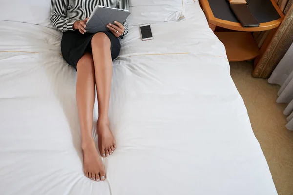 Geschäftsfrau liegt im Bett und arbeitet an Tablet — Stockfoto