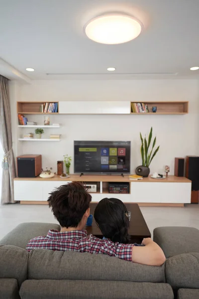 Couple sitting on sofa and hugging — Stock Photo, Image