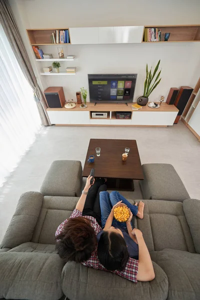 Pár sedí na pohovce a dívat na televizi — Stock fotografie