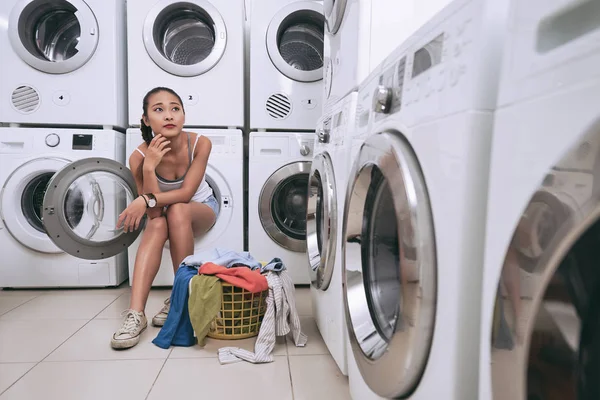 Женщина сидит в стиральной машине — стоковое фото