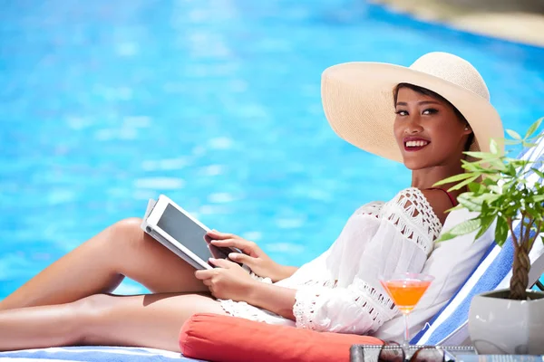 Dame avec tablette assis près de la piscine — Photo