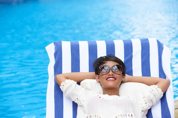 Vrouw in zonnebril ontspannen in chaise-lounge — Stockfoto