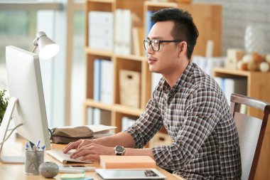 bilgisayarda çalışarak gözlüklü adam