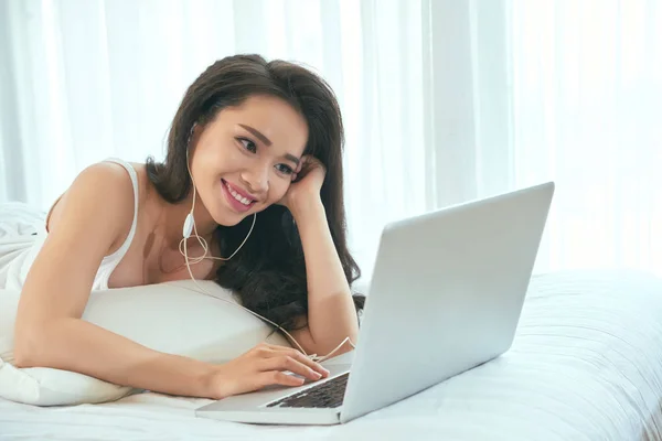 Menina com fones de ouvido assistir vídeo no laptop — Fotografia de Stock