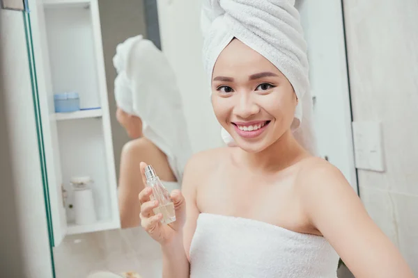 Mujer aplicando perfume después de tomar la ducha — Foto de Stock