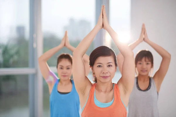 Kvinnor som tränar yoga poserar tillsammans — Stockfoto