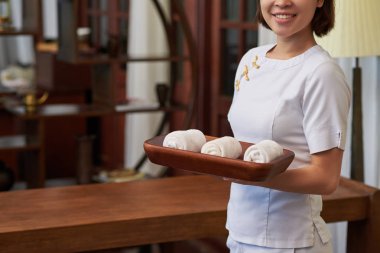 Hizmetçi ile küçük havlu tepsiye haddelenmiş.