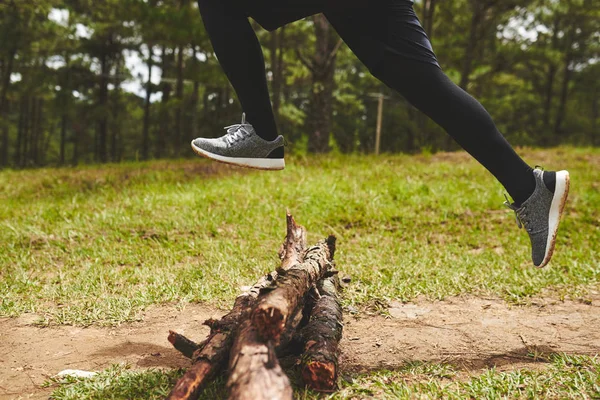 Desportista saltar sobre logs — Fotografia de Stock