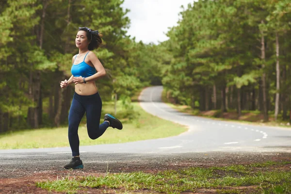 Vrouwelijke jogger loopt langs de weg — Stockfoto
