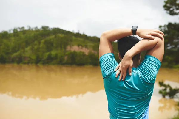 Homem em pé junto ao lago e braços esticados — Fotografia de Stock