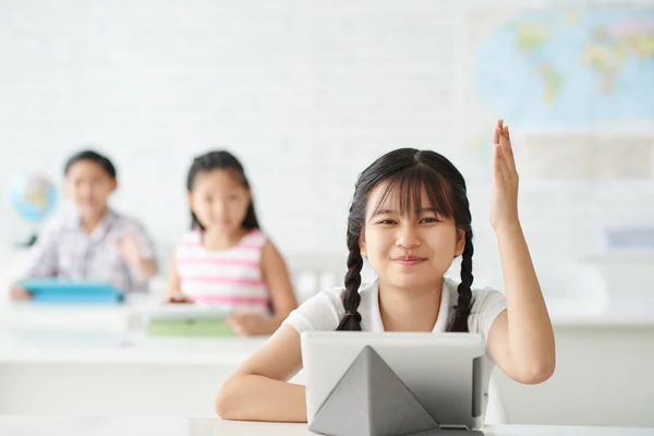 Colegiala levantando la mano para responder a la pregunta —  Fotos de Stock