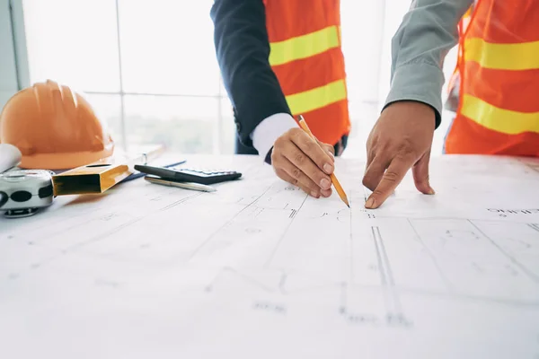 Werknemers in de bouw op de blauwdruk van het gebouw — Stockfoto