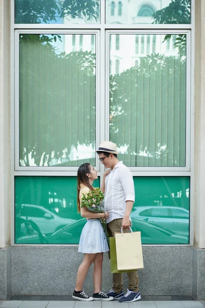 Par kyssar framför fönstret — Stockfoto