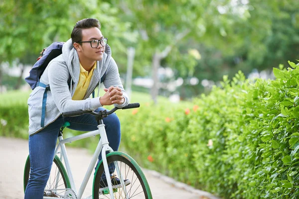 Студент сидить на велосипеді в парку — стокове фото