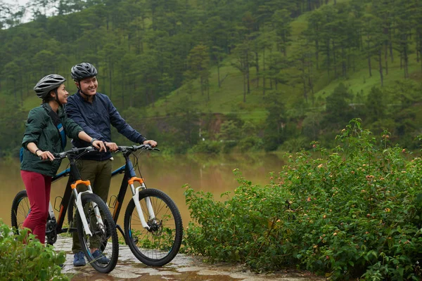 Pareja disfrutando del ciclismo en el bosque — Foto de Stock