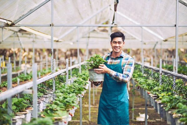 Young farmer carrying pot Stock Image