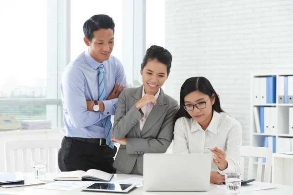 Equipo discutiendo información en la pantalla del ordenador portátil —  Fotos de Stock