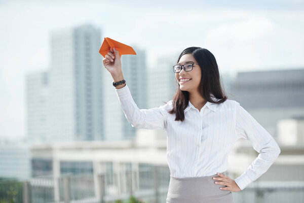 woman launching paper airplane