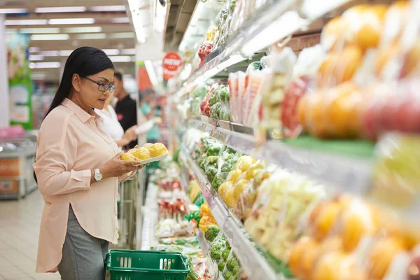 Mujer elegir verduras en el supermercado — Foto de Stock