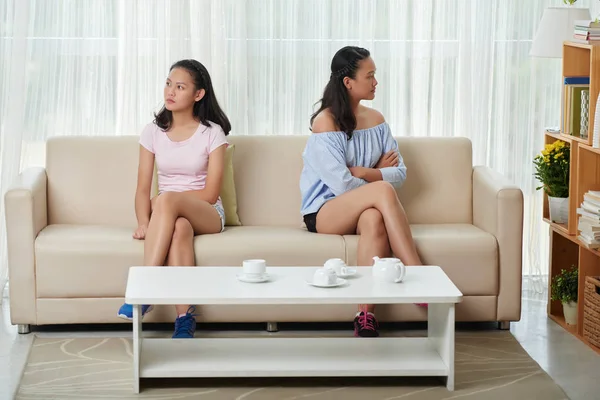 Сестры сидят на диване после ссоры — стоковое фото