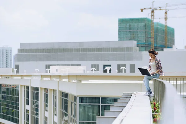 Dívka sedí na střeše budovy — Stock fotografie