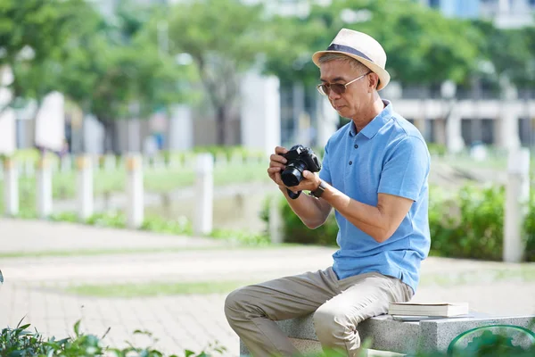 カメラの写真を見ている男 — ストック写真