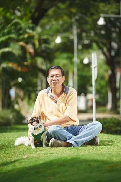 Hombre y perro descansando en el parque — Foto de Stock