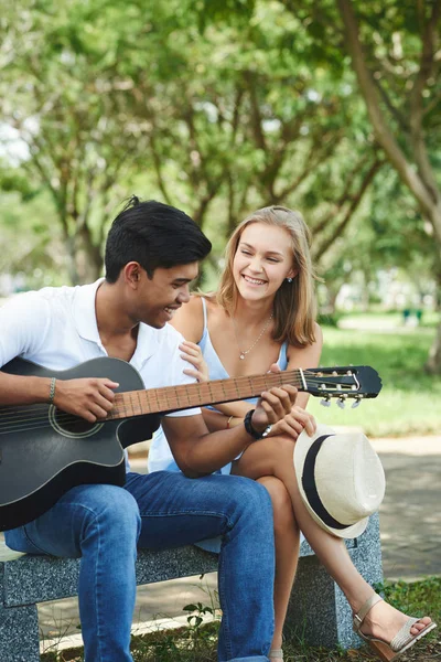 Casal multicultural tocando na guitarra acústica — Fotografia de Stock