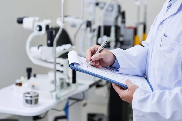 Doctor filling medical case history — Stock Photo, Image