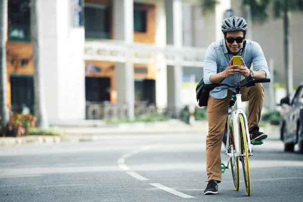 Mensagens de texto do homem ao andar de bicicleta — Fotografia de Stock