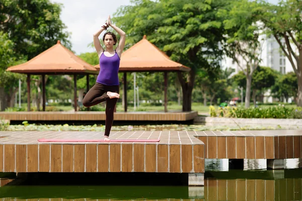 Mulher praticando posição de árvore de ioga — Fotografia de Stock