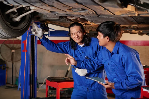 Zkušení mechanici učí spolupracovníka — Stock fotografie